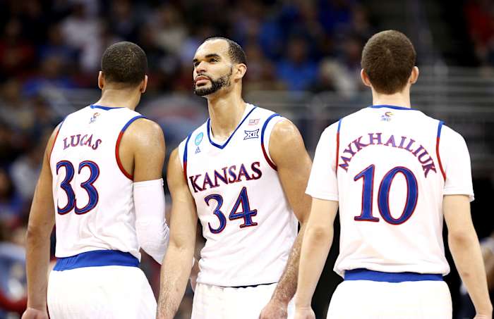 Mar 26, 2016; Louisville, KY, USA; Kansas Jayhawks forward Perry Ellis (34) reacts with forward Landen Lucas (33) and Sviatoslav Mykhailiuk against the Villanova Wildcats during the first half of the south regional final of the NCAA Tournament at KFC YUM!. Mandatory Credit: Aaron Doster-USA TODAY Sports